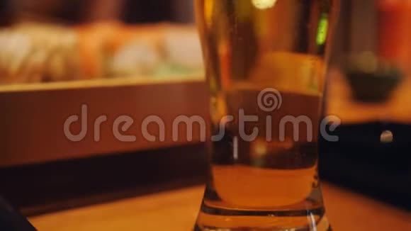 关闭酒吧或餐厅柜台上的啤酒杯泡沫的镜头视频的预览图