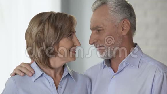 快乐的老夫妇互相看着对方微笑着看着镜头做广告视频的预览图