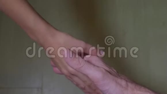 爸爸和孩子握手将成年白种人和小白种人的男性双手隔离视频的预览图