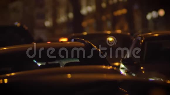 在模糊的灯光背景下拍摄夜间城市中移动汽车的特写镜头视频的预览图