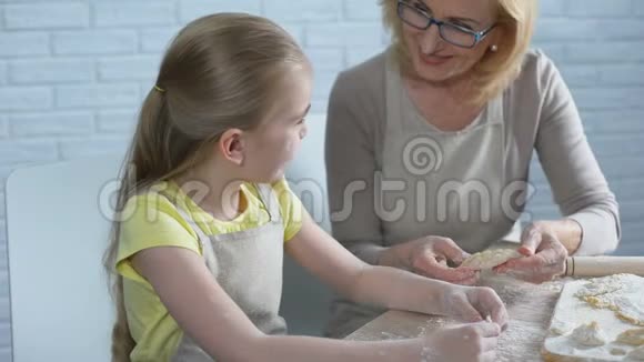漂亮的女学龄前儿童想做糕点帮她奶奶做厨房视频的预览图