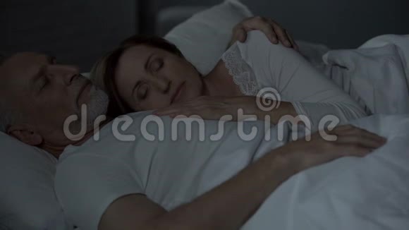 老夫妻睡在床上女人把头放在男人的胸膛上爱视频的预览图