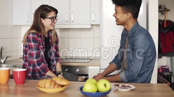 可爱的浪漫夫妇坐在厨房里进行有趣的谈话微笑着笑视频的预览图