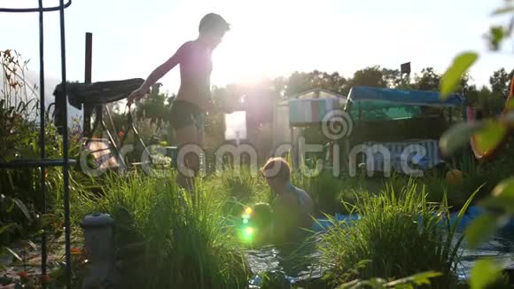 在炎热的夏天一家人在一个小湖里游泳男孩跳进水里造成水溅花园视频的预览图