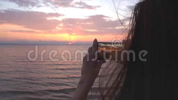 年轻女子拍摄日落的视频视频的预览图