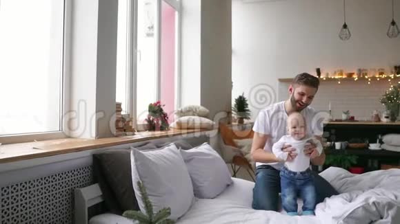 父亲和可爱的小女儿躺在家里的床上视频的预览图