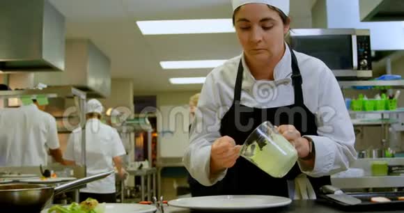 女厨师在盘子里放酱汁4k视频的预览图
