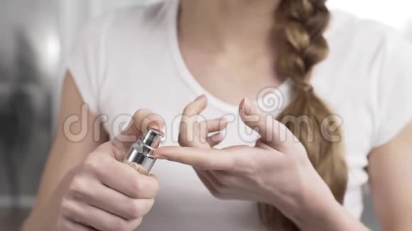 女人把一滴奶油从瓶子分配器挤压到指尖面部和身体护理身体化妆品视频的预览图