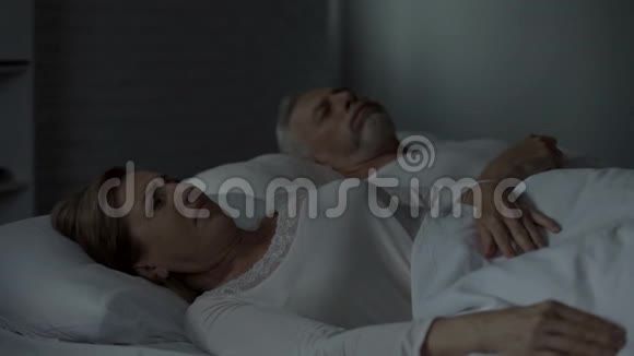 男人在床上打鼾旁边的女人用双手抵住耳朵睡得不好视频的预览图