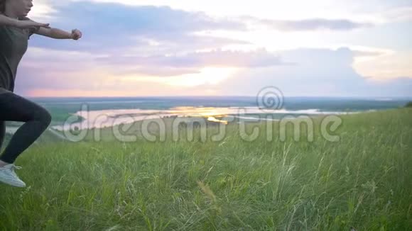 夏日夕阳下一位运动的年轻女子在草地上表演翻盖视频的预览图