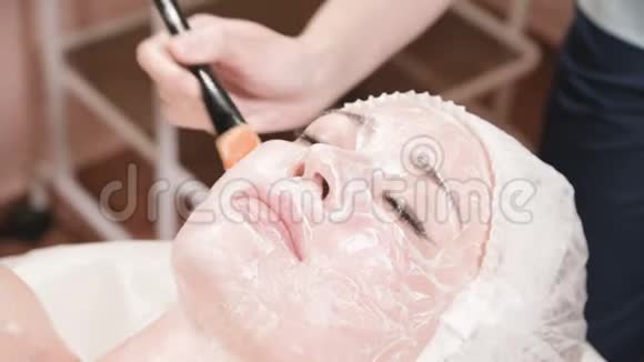 这个美容师的女孩做清洁和滋润皮肤的手术敷一个带特殊面膜视频的预览图