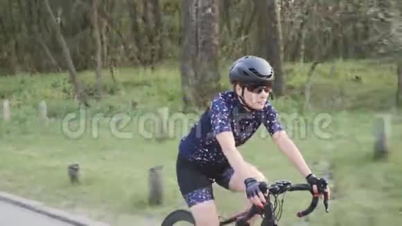 在公园里骑着自行车跟着女三项运动员的镜头侧视铁人三项训练理念视频的预览图