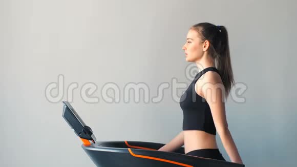 运动的女人在健身房跑步机上行走视频的预览图