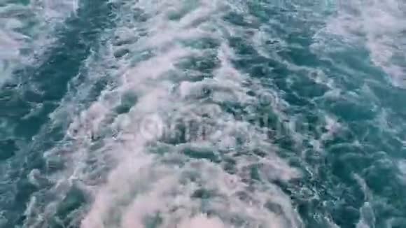 强大的波浪跟随着船从船上的引擎追踪游轮在蓝色的海洋上航行后面的波浪视频的预览图
