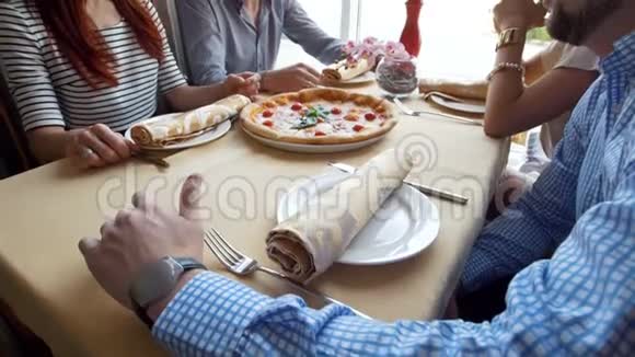 朋友们在咖啡馆里吃披萨那家伙给别人看笑话视频的预览图