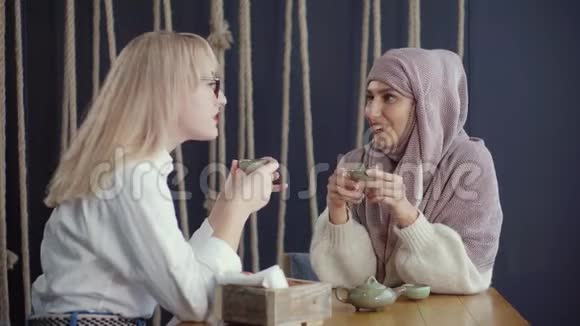 不同的传统宗教和种族的女人坐在咖啡馆里视频的预览图