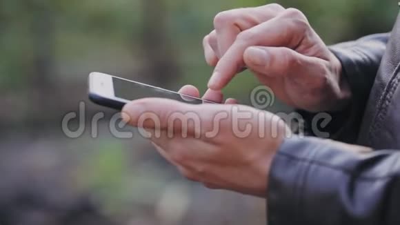男人用手机滚动照片检查邮件视频的预览图