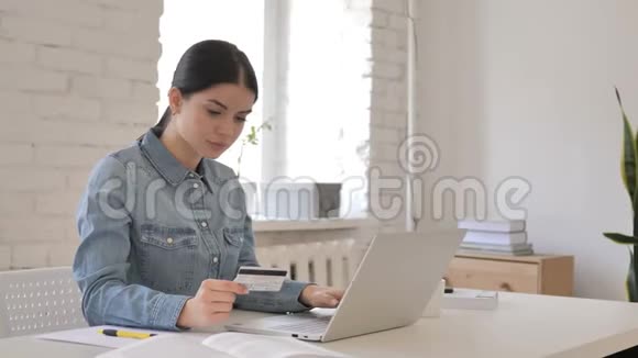 年轻女孩用信用卡在线购物视频的预览图