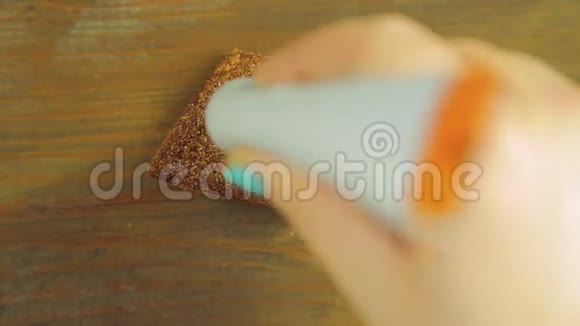 一只手握着一管烹饪颜料在一块巧克力饼干上画出带有棕色颜料的滑稽表情视频的预览图