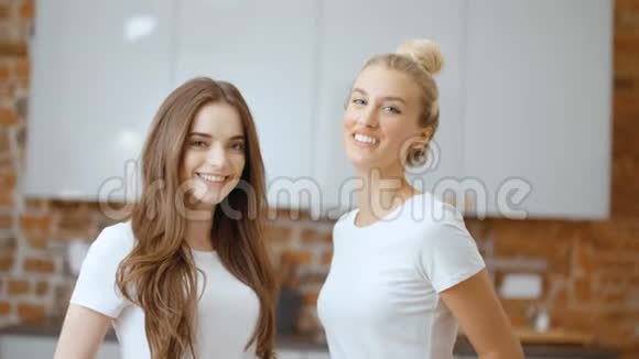 两个快乐的少女女友看着镜头微笑的肖像视频的预览图
