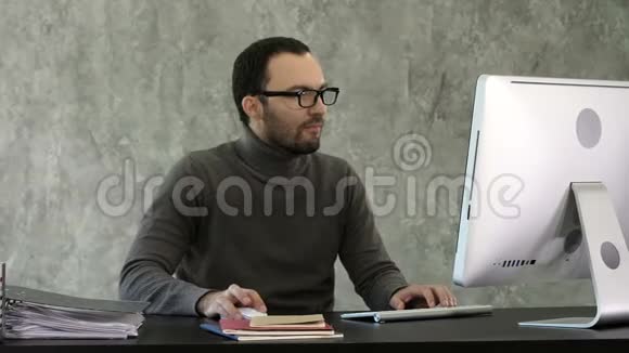 商人坐在办公室的办公桌上对着电脑发呆视频的预览图