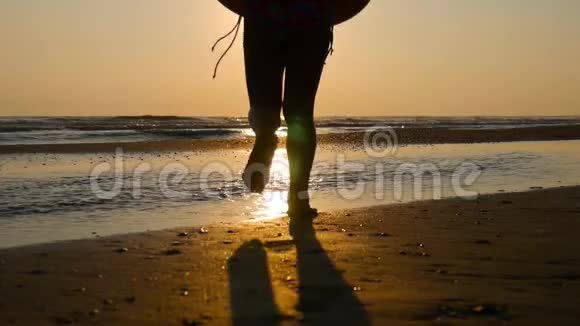 日落时分快乐的女孩在海滩上玩耍日落时在浅水中奔跑的女孩孩子在水里玩视频的预览图