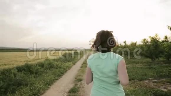 年轻的白人妇女享受生活在西班牙乡村道路上奔跑穿过农村麦田景观视频的预览图