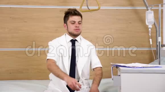 年轻的医生穿着白色长袍检查灌注而第二个医生手里拿着一个夹子进入框架视频的预览图