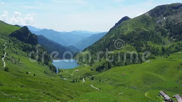 意大利阿尔卑斯山意大利春天的绿色草地牧场和人工湖视频的预览图