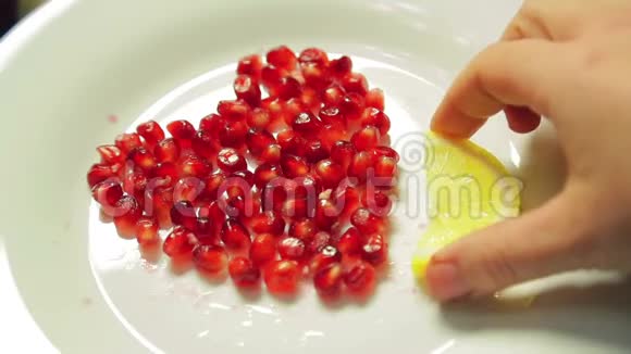 石榴籽的心脏放在用柠檬片装饰的白色盘子上视频的预览图