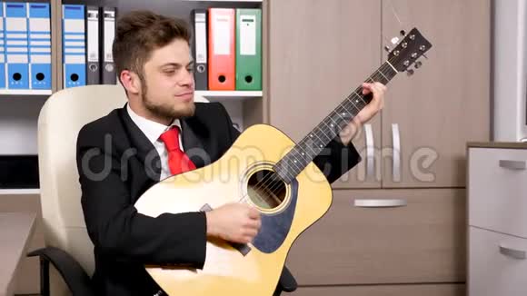 年轻的商人穿着正式西装弹吉他视频的预览图