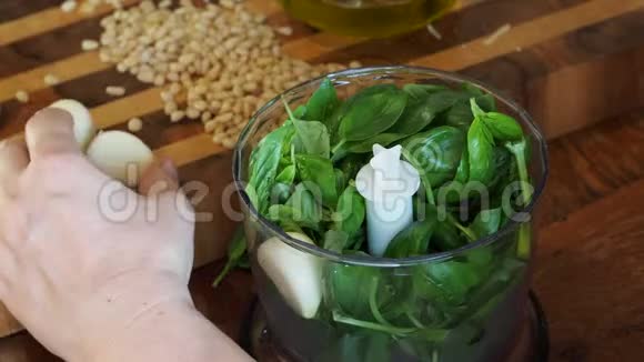 厨房搅拌机里放大蒜和新鲜的绿色罗勒叶视频的预览图