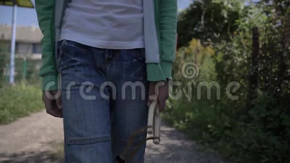 口袋里有弹弓的男孩在户外乡间小路上散步视频的预览图