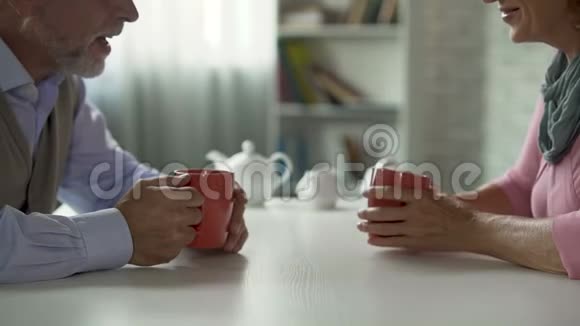 一对年老的男人和女人在桌子上喝茶学校的情人见面视频的预览图