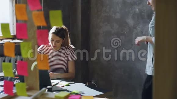 当她的同事进入办公室时女设计师正在使用笔记本电脑她在听错然后起飞视频的预览图