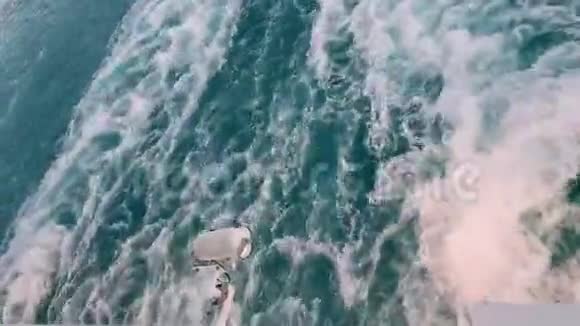 强大的波浪跟随着船从船上的引擎追踪游轮在蓝色的海洋上航行后面的波浪视频的预览图