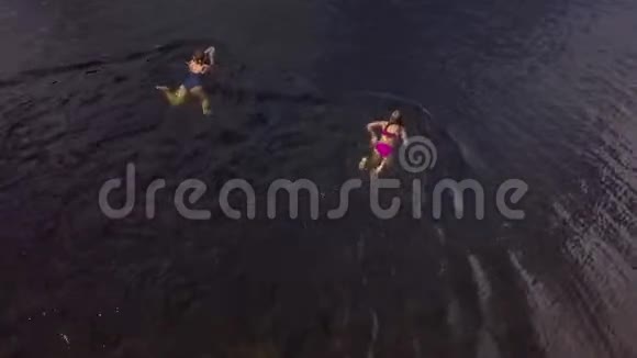 顶部空中景观女孩和少女漂浮在湖里视频的预览图