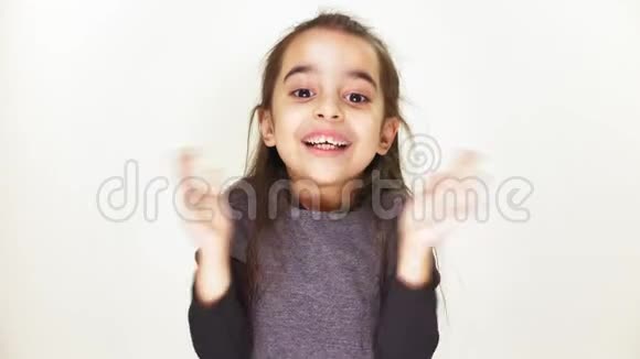 可爱开朗的小女孩微笑着拍手喜悦着白色背景每秒50帧视频的预览图
