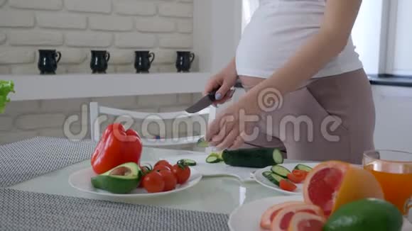 健康的未来妈妈大肚子正在做有益的开胃沙拉从新鲜蔬菜中提取出来用于午餐美食视频的预览图