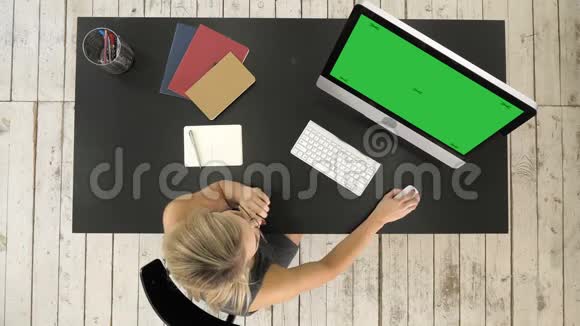 女孩在电脑屏幕上看绿屏模拟显示视频的预览图