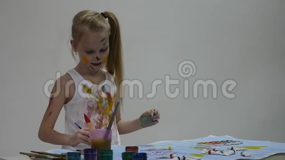 金发的女学生画家画自己和她的衣服慢动作视频的预览图