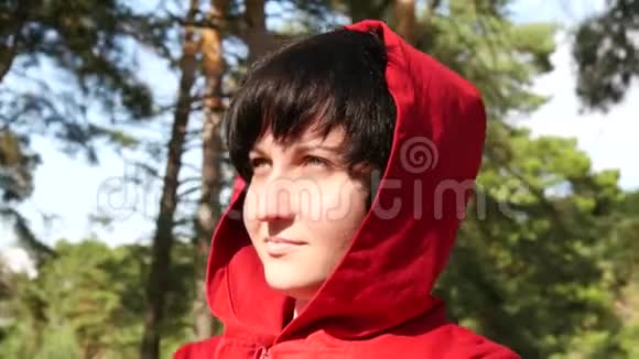 一个年轻女人的肖像女孩在森林里的新鲜空气中阳光照在脸上视频的预览图