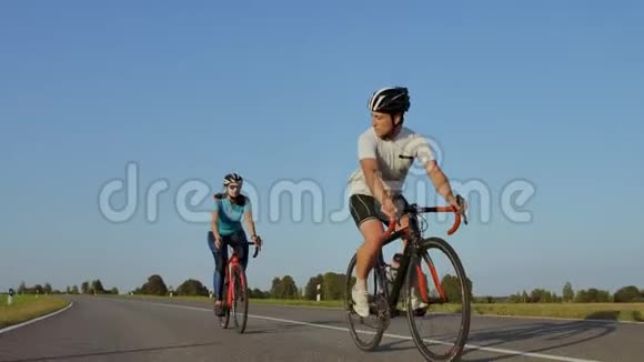 艰苦的训练铁人三项两名自行车手在公路自行车上训练两个骑着公路自行车的人在城市公园里视频的预览图