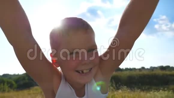 一个阳光明媚的日子父亲在草地上给他快乐的儿子纺纱爸爸在大自然中旋转微笑的男孩封闭情绪视频的预览图