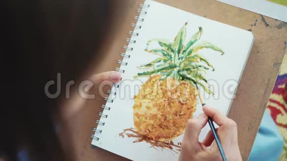用画笔特写女性的手正在用水彩画菠萝视频的预览图
