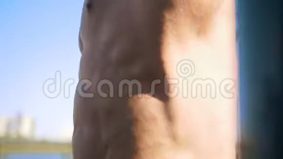 一个肌肉发达的家伙在运动场抖他的腹肌视频的预览图