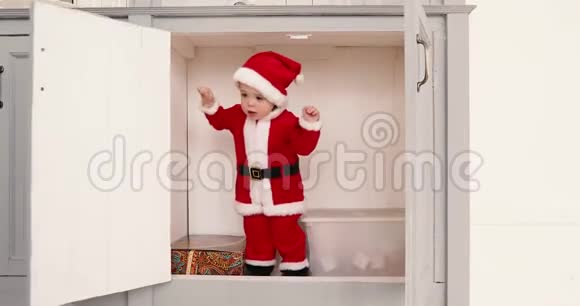 穿着圣诞老人套装的男婴从里面打开衣柜视频的预览图