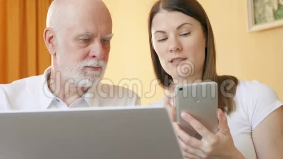 年长的父亲和年轻的女儿使用智能手机青少年教爷爷如何使用手机视频的预览图