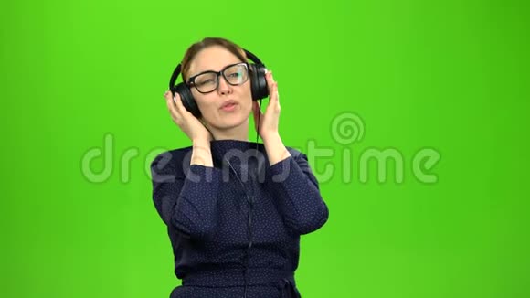 老师在耳机上听音乐绿色屏幕视频的预览图