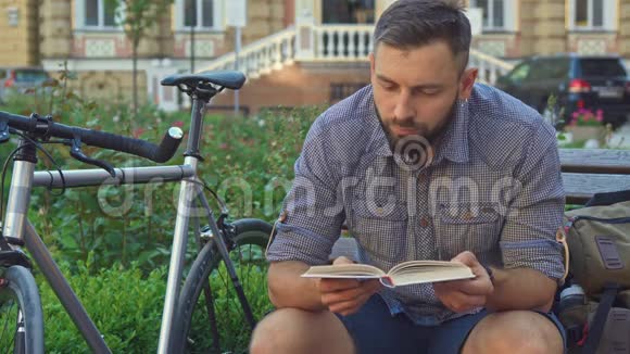 骑自行车的人在长凳上看书视频的预览图